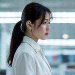 真剣な表情の女性品質管理責任者が顕微鏡で生地を検査している写真